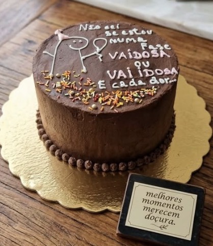 Bolo de chocolate com mensagem escrita em creme branco