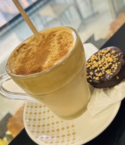 Galão polvilhado com canela e um doce de chocolate